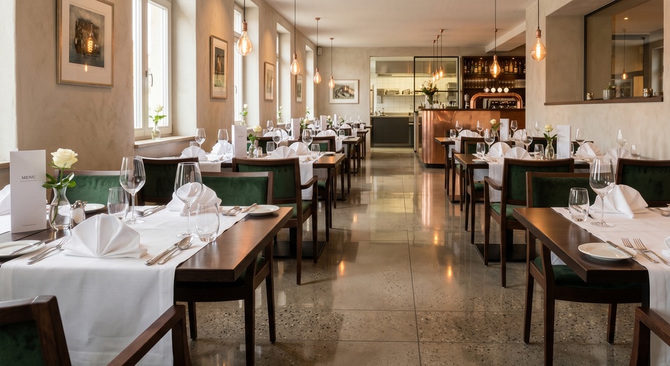 Einladender Restaurant-Gastraum mit blitzsauberen Tischen, polierten Gläsern und glänzendem Boden