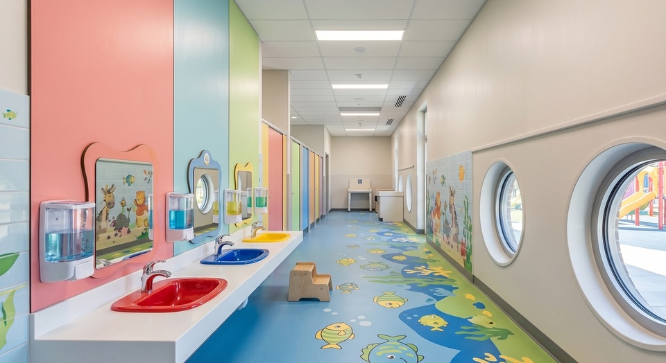Kindgerechter Sanitärbereich: saubere Waschbecken in niedriger Höhe, desinfizierte Griffe und gefüllte Spender